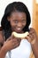 Smiling Afro-American woman eating melon