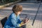 Smiling afro haired girl writes on her mobile phone sitting on a bench