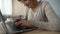 Smiling aged lady typing message on laptop, communicating on dating website