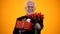Smiling aged man in suit presenting tulips bouquet and giftbox, sincere greeting
