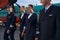 Smiling airplane crew members walking together on runway