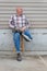 Smiling amputee man sitting on a stool, holding crossed prosthetic leg at the ankle