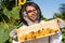 smiling apiarist in beekeeping suit holding