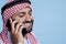 Smiling arab answering smartphone call