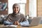 Smiling arab girl looking for job online, sitting at cafe