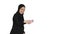 Smiling Arab woman in hijab taking selfies on her mobile phone as she walks on white background.