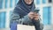 Smiling Arabic lady outdoors chatting on phone after successful shopping fashion