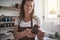 Smiling artisan standing in her creative studio inspecting pottery