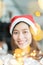 Smiling asia woman wear santa hat holding party string lights wi