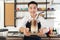 Smiling Asian barista man hold cup of ice beverage to show the  customers in the coffee shop