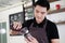 Smiling Asian barista young man pouring fresh Chocolate art in a plastic glass of Cappuccino iced coffee