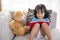 Smiling Asian Chinese little girl reading book with teddy bear