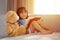 Smiling Asian Chinese little girl reading book with teddy bear