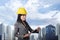 Smiling asian contractor woman with yellow helmet holding clipboard