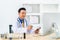 Smiling Asian doctor with digital tablet looking at camera. Remote online medical chat consultation, tele medicine distance
