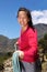 Smiling asian female climber with rope on mountain