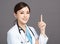 Smiling asian female doctor hand point up