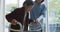 Smiling asian female doctor helping senior female patient to walk using walking frame