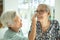 Smiling asian female elderly person wipe sweat on the skin face of the senior sister and talk happily,old people visited her  aged