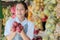 Smiling asian lady shop assistant carrying fresh red apples on the background of a fresh fruit