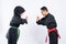 Smiling Asian men and women wearing pencak silat uniforms stand face to face with bowing respect to each other