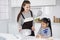 Smiling Asian mother and little asian girl child is cooking and Form bread dough for baking bakery in kitchen. Homemade pastry and