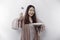 A smiling Asian Muslim woman is fasting and hungry and holding and pointing to a plate