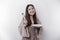 A smiling Asian Muslim woman is fasting and hungry and holding and pointing to a plate