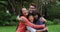 Smiling asian parents hugging happy son and daughter in garden