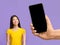 Smiling Asian Woman Looking Aside At Blank Smartphone In Huge Female Hand