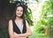 Smiling Asian woman standing in  garden with arms crossed looking to camera. heath and happiness, spending time alone at home