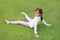 Smiling Asian young girl child lying on green lawn at the garden. Kid lies on grass with looking camera