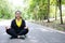 Smiling Asian young woman in sportwear close her eyes and sitting for doing yoga of meditation for create concentration and calm