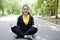 Smiling Asian young woman in sportwear sitting and doing yoga for meditation for create concentration and calm the mind.