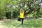 Smiling Asian young woman in yellow sportwear standing and doing yoga for meditation for create concentration and calm the mind.