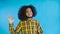 Smiling attractive Afro-American guy showing ok gesture while standing isolated over Blue background. Concept of