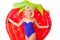 Smiling attractive blonde girl in a sexy swimsuit on a background of strawberry swimming mattress