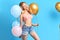 Smiling attractive chic girl with closed eyes holding balloons