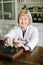 Smiling attractive middle-aged blond lady pharmacist working with vintage scales in the pharmacy