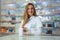 Smiling attractive woman pharmacist displaying a box of tablets