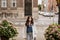 Smiling attractive woman wearing white fashion jacket and jeans look away