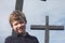 Smiling Autistic Boy in Front of a Cross