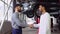 Smiling auto mechanic and indian client shaking hands in service