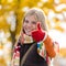 Smiling autumn teenager girl thumbs up forest