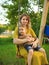 Smiling baby boy and mother ride on swing in playground on green lawn. Summertime photo for ad or blog about motherhood