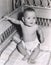 Smiling baby boy sitting in crib