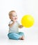 Smiling baby boy with yellow ballon in his hand