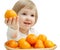The smiling baby girl is showing the tasty tangerine