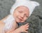 Smiling baby in hat sleeping on gray blanket