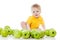 Smiling baby with many green apples